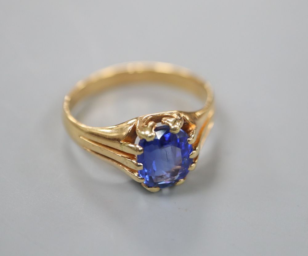 A yellow metal and claw set oval cut sapphire ring, the shank with fluted shoulders, size O/P, gross 4.9 grams.